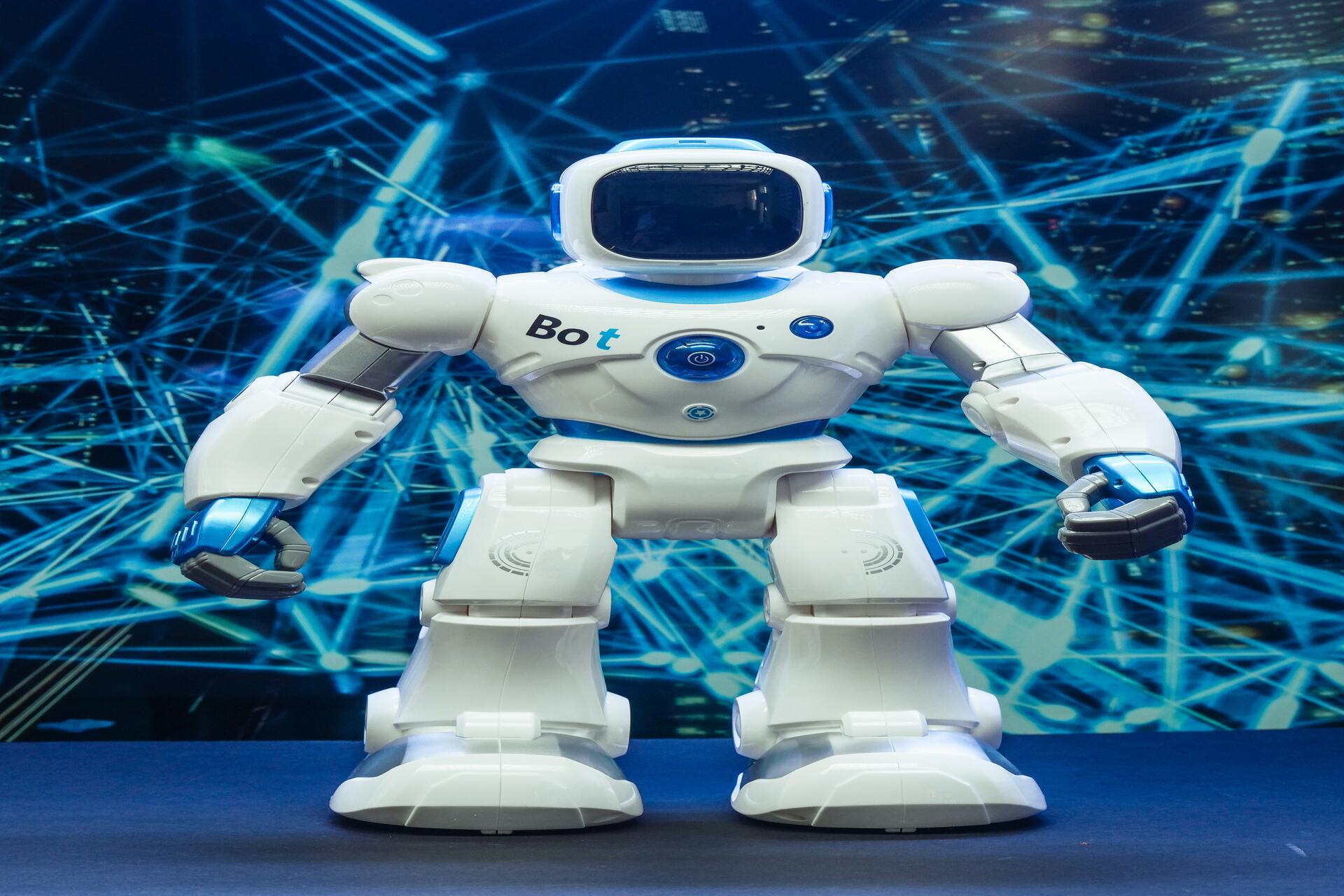 White toy robot standing on a desk