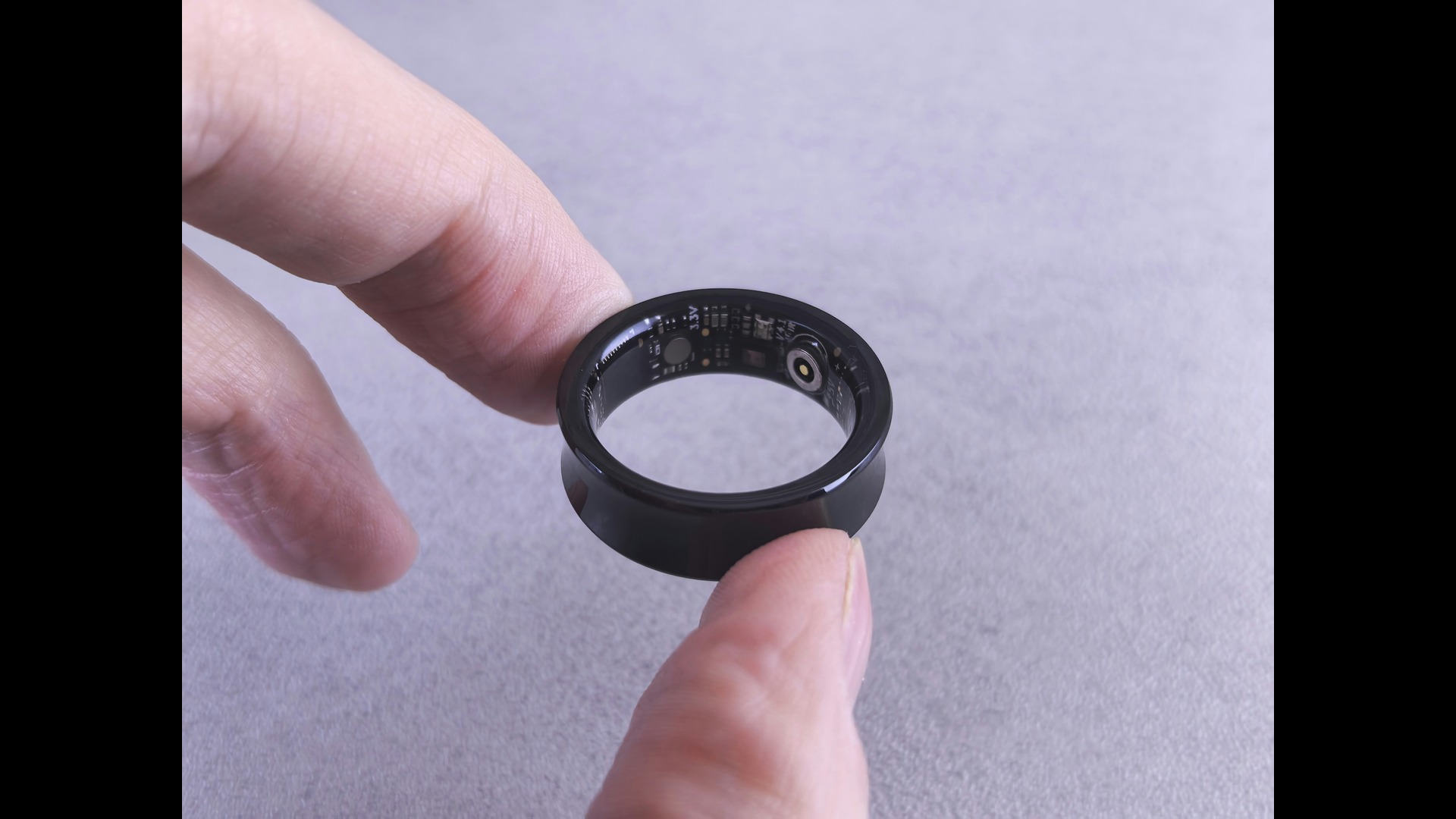 photo of a hand holding a black smart ring