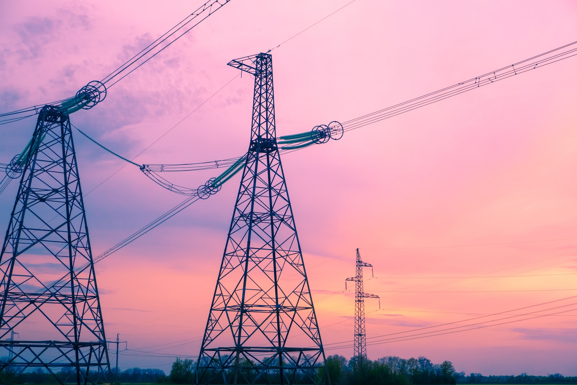 Power transmission towers in front of a sunset