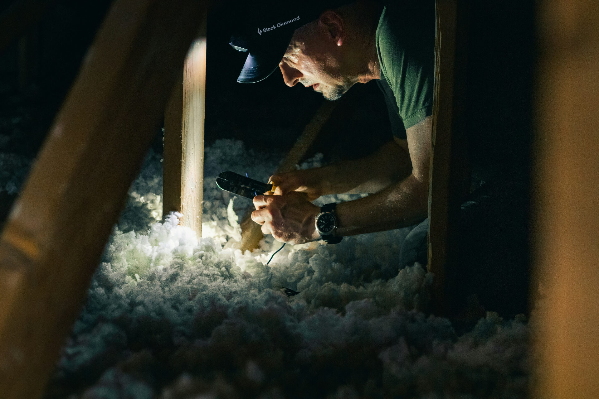 person working with insulation with head lamp