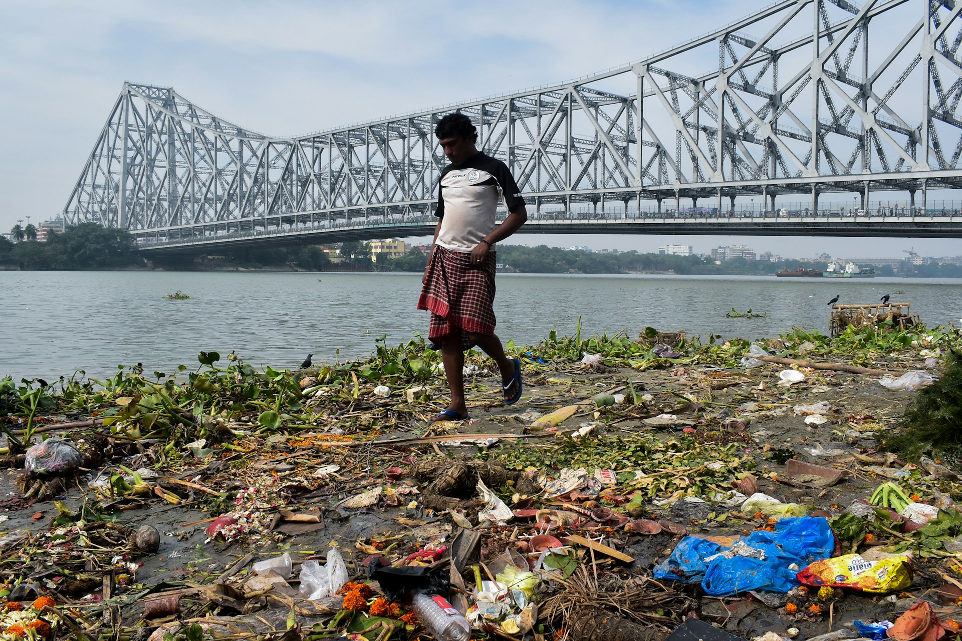 Man walking on trash near water