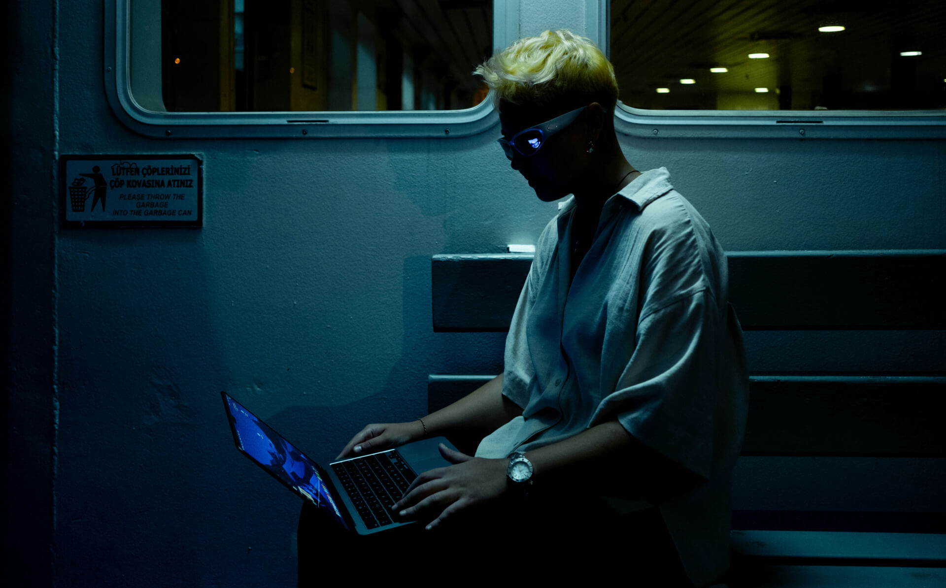 person sitting in the dark looking at a laptop