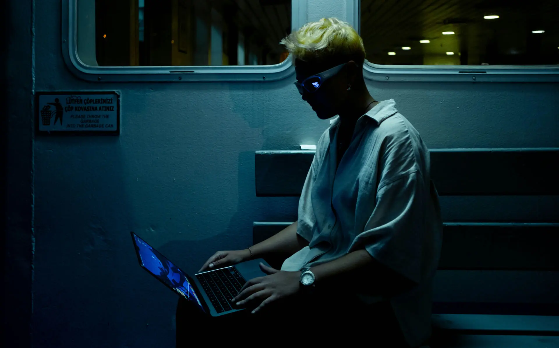 person sitting in the dark looking at a laptop