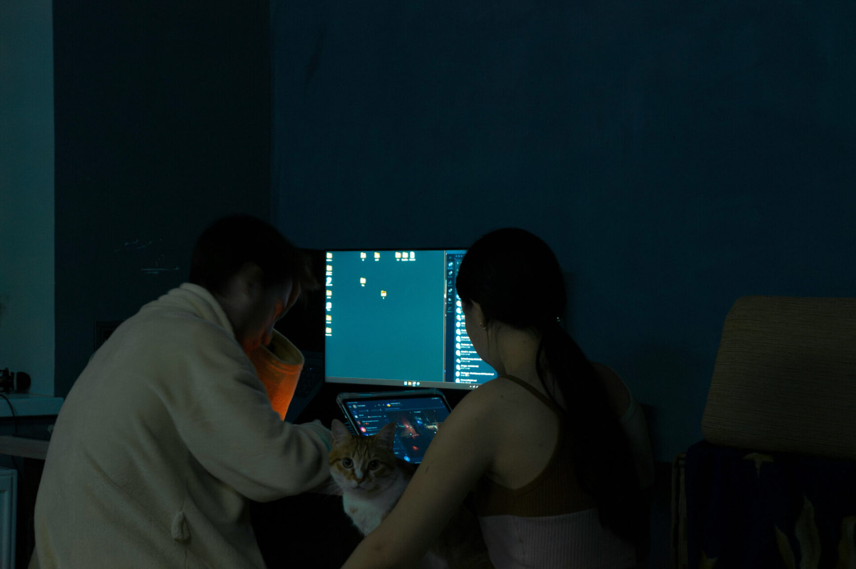two people sitting near computer monitor